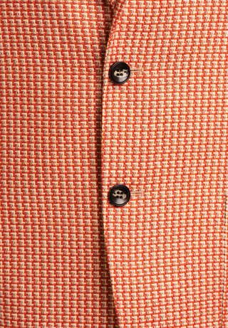 Close-up of a textured orange fabric with two buttons.